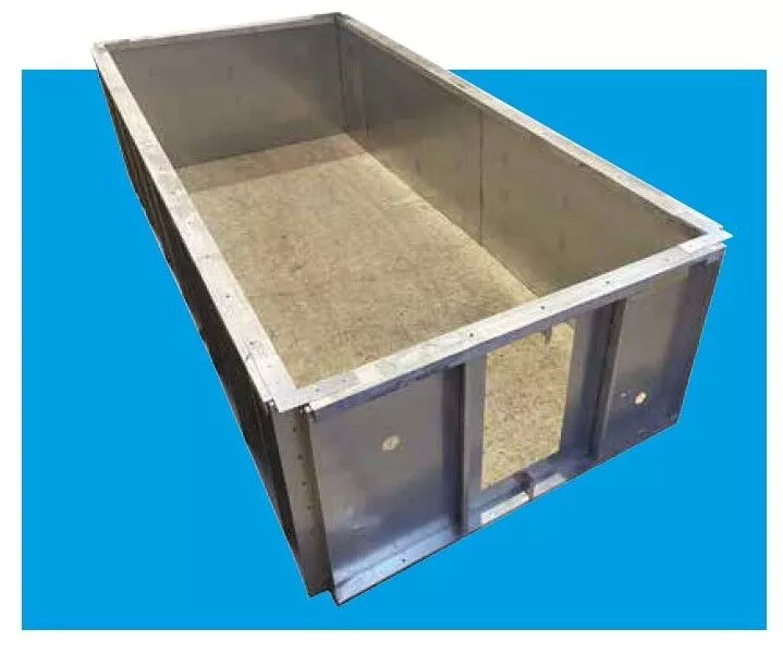 Rectangular metal open-top form with riveted sides and textured interior rests angled on a solid bright-blue background.