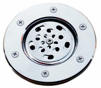 Circular chrome drain cover sits mounted flush, showing perforated center plate with curved slots and central screw, surrounded by rim with six evenly spaced screws against a plain white background.