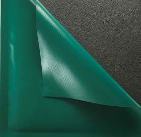A teal green vinyl sheet peels back at a corner, revealing its lighter underside while lying flat on a coarse dark gray textured surface.