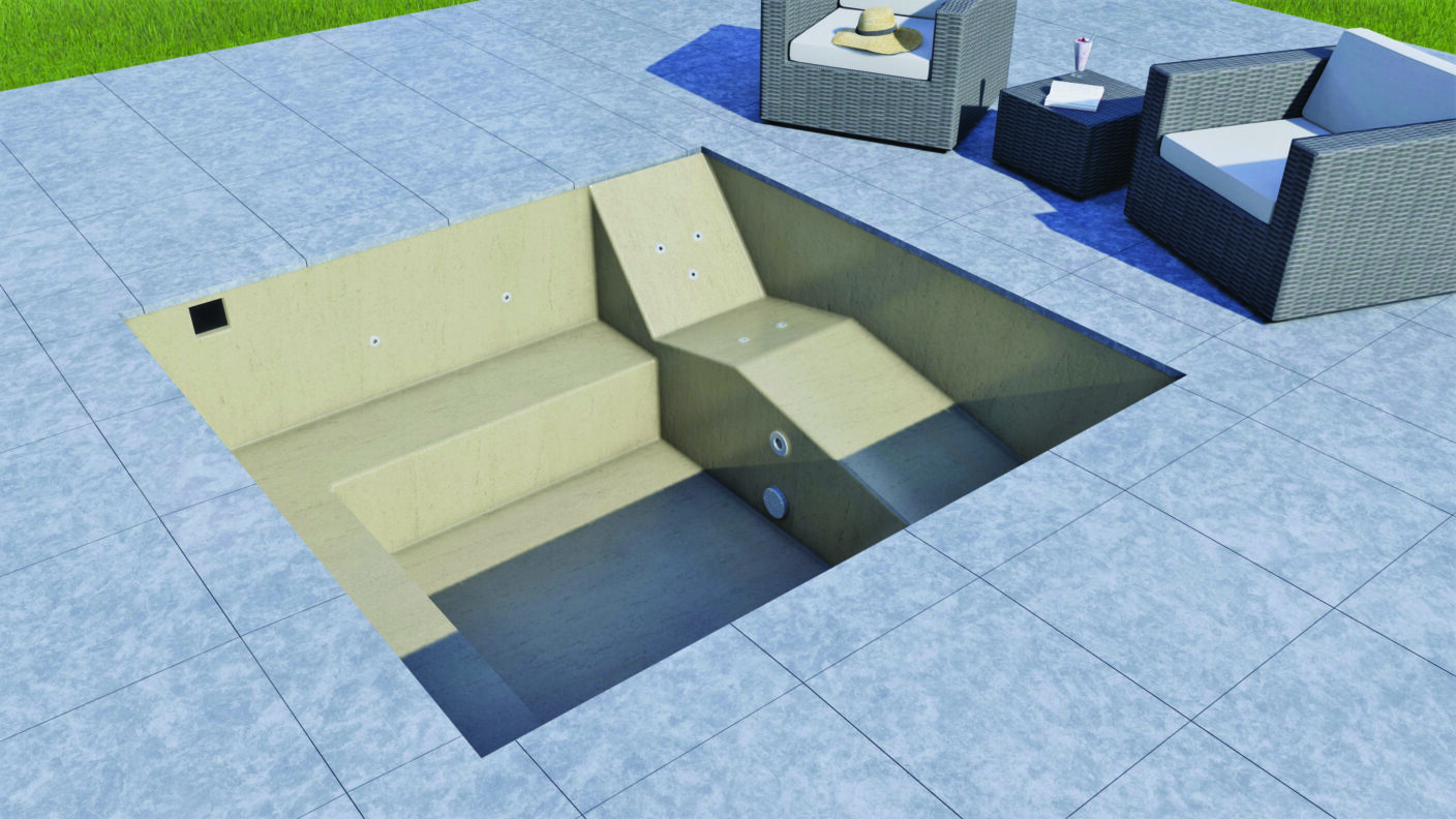 An empty sunlit plunge pool sits recessed into a tiled patio, showing steps and jets, with nearby wicker lounge chairs, side table with a hat, drink and lawn.