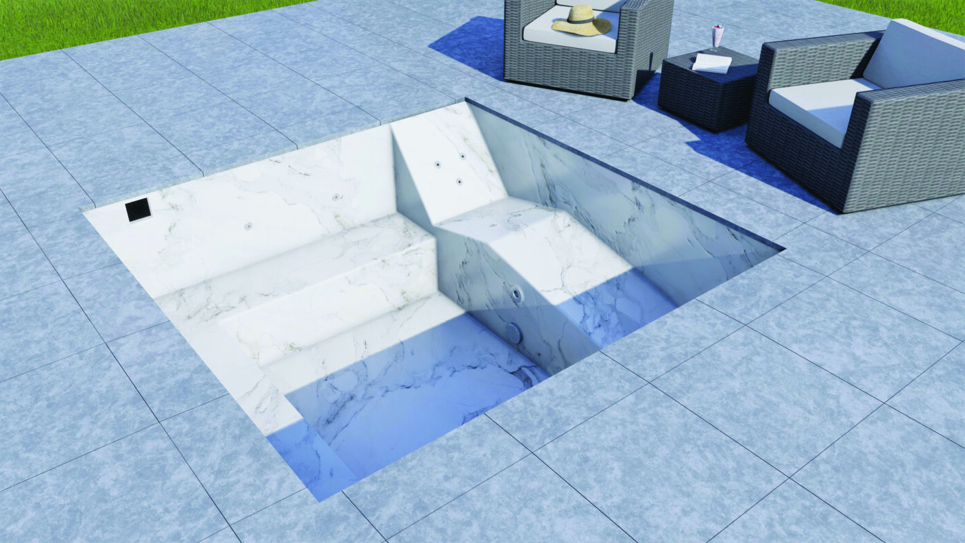 A recessed marble pool sits empty, revealing built-in steps, bench seating and jets, set in a tiled patio beside wicker armchairs, a side table with hat and drink and lawn.
