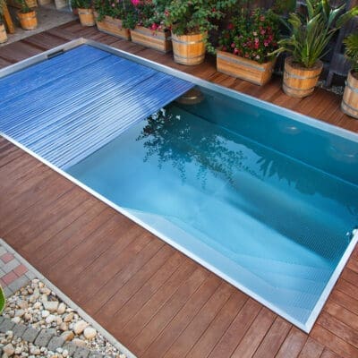 Rectangular pool with slatted cover on wooden deck