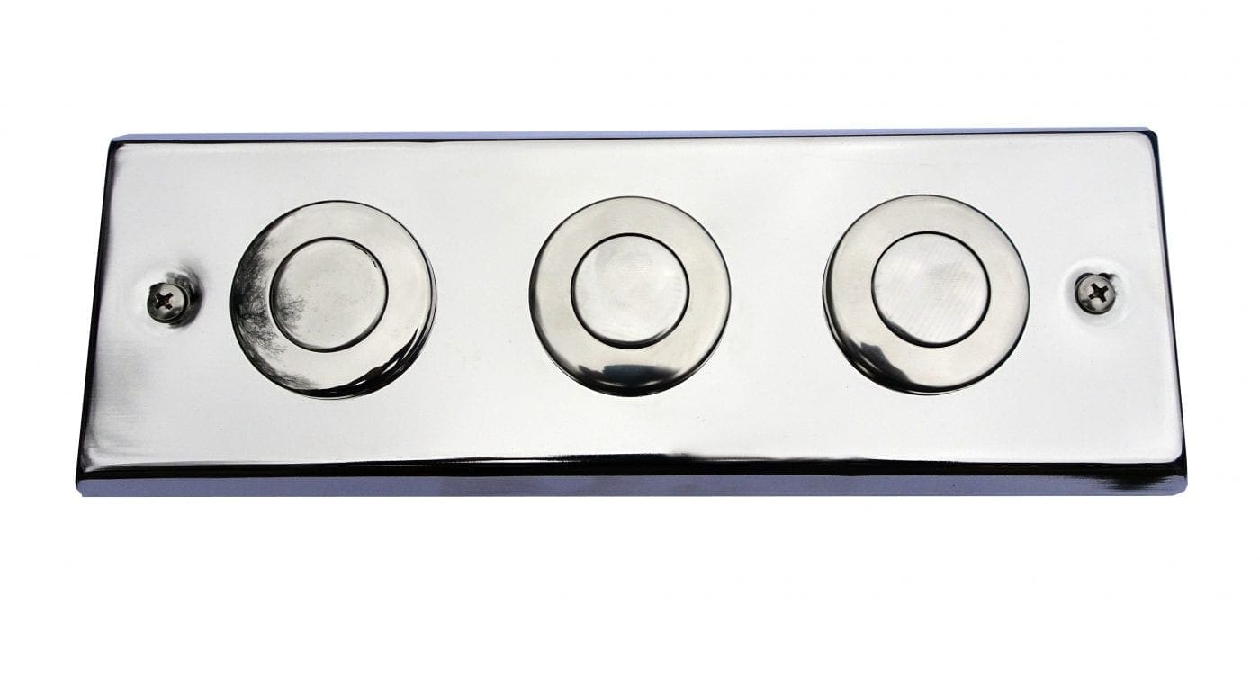 Polished chrome rectangular plate holding three circular push buttons and two crosshead screws, mounted flat against a white background and reflecting faint surrounding shapes.