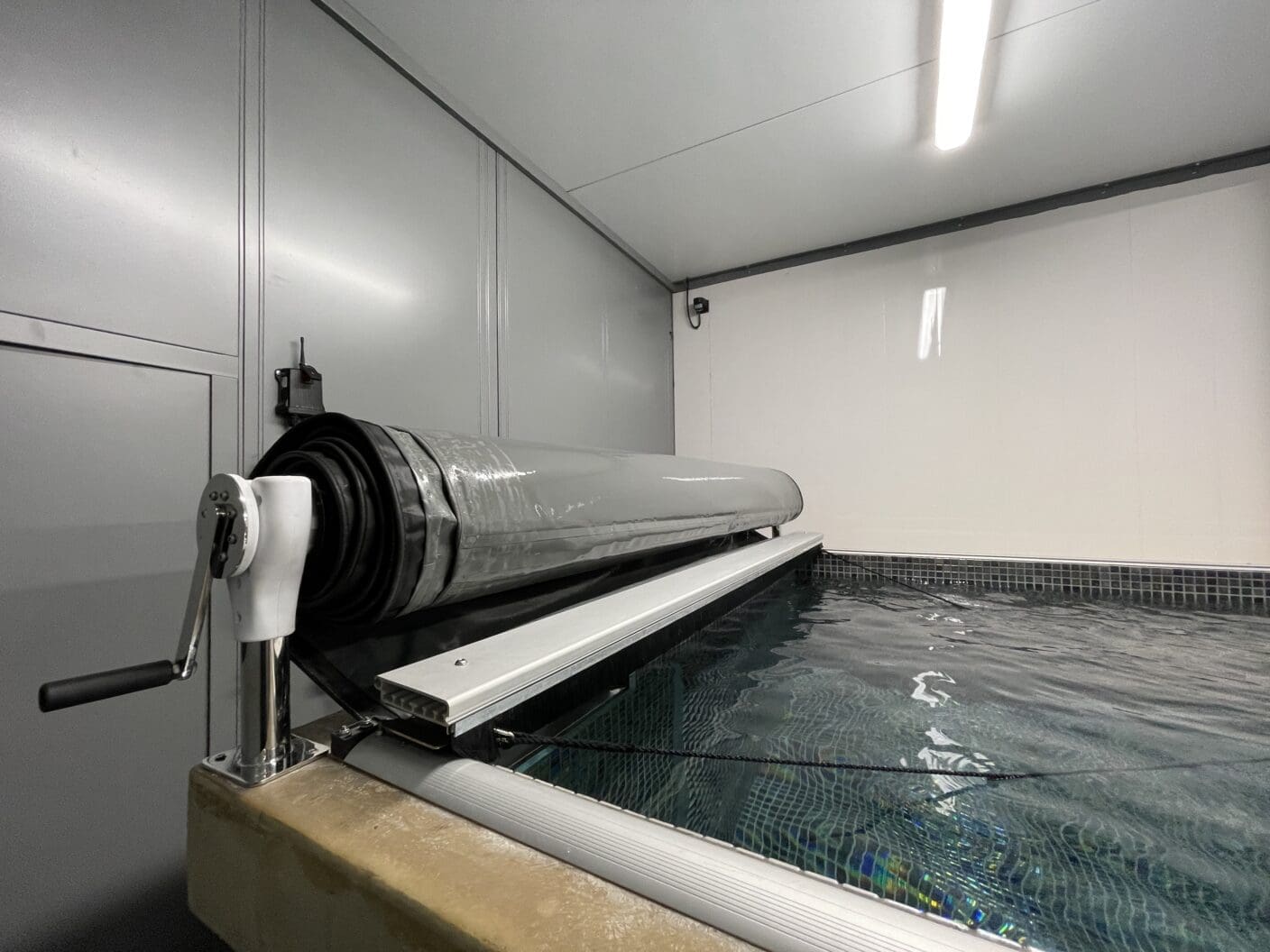 Indoor pool with manual roller cover system