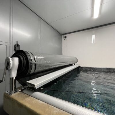 Indoor pool with manual roller cover system
