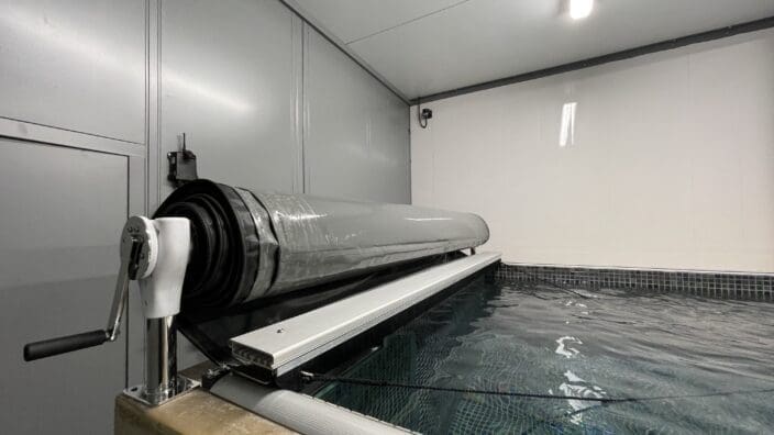 Indoor pool with manual roller cover system