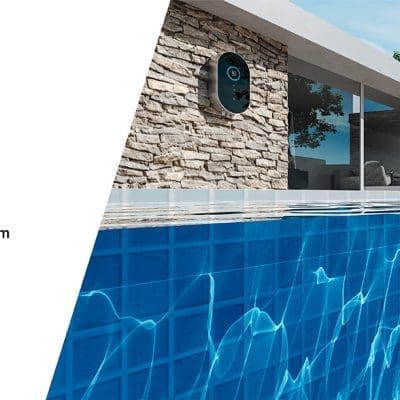 Blue robotic pool cleaner clings to a tiled pool wall, cleaning underwater; modern stone-and-glass house and patio with trees beyond; text: Plug-in luxury; Ultra-slim for space-saving; Ideal for all-size pool from 5*3m.